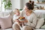 Mama su kūdikiu laiko šviežius vaisius – simbolizuoja sveiką mitybą imuniteto stiprinimui